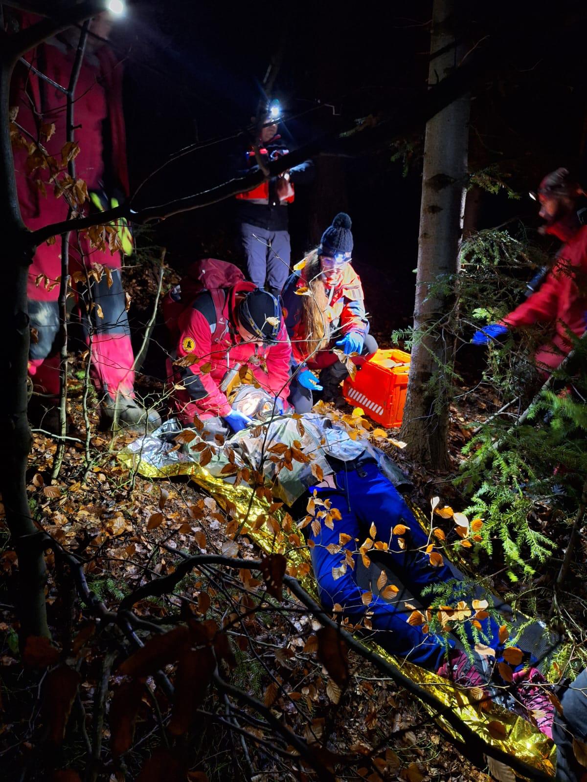 Nocna akcja ratownicza w lesie — poszkodowany w kocu termicznym, zespół z czołówkami